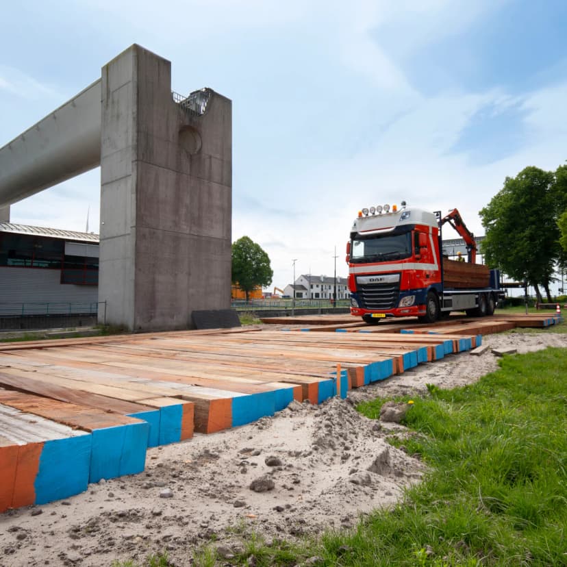 Vrachtwagen rijdt op draglineschotten op een bouwterrein